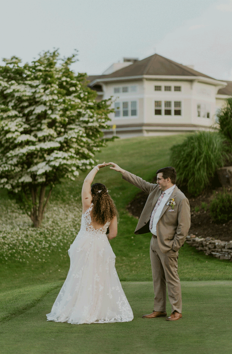 Groom twirls his bride while admiring her in her wedding attire.