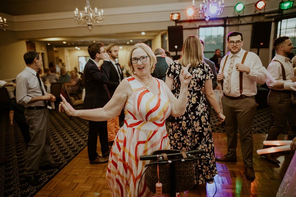 Wedding guest dancing happily with other guests.
