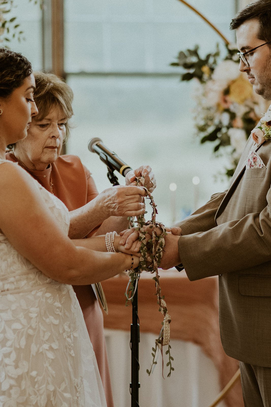 Bride and groom doing their handfasting during their ceremony.