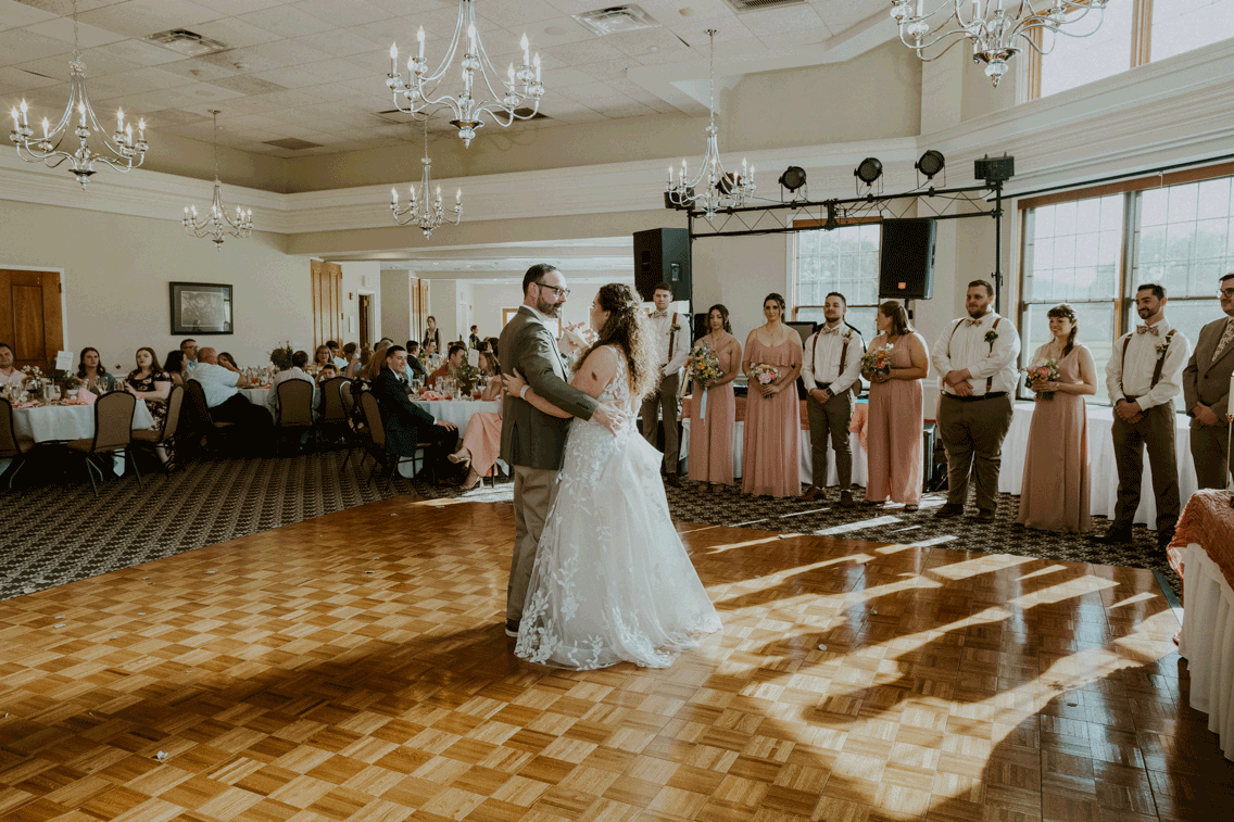 Bride shares a dance with a family member. 