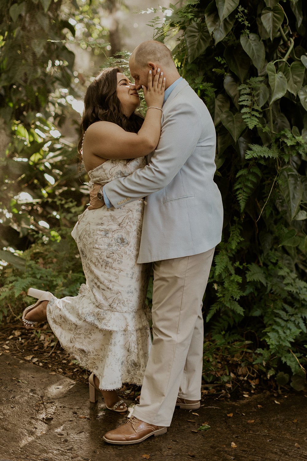 The bride reaches in for a kiss from her groom during their engagement session. 