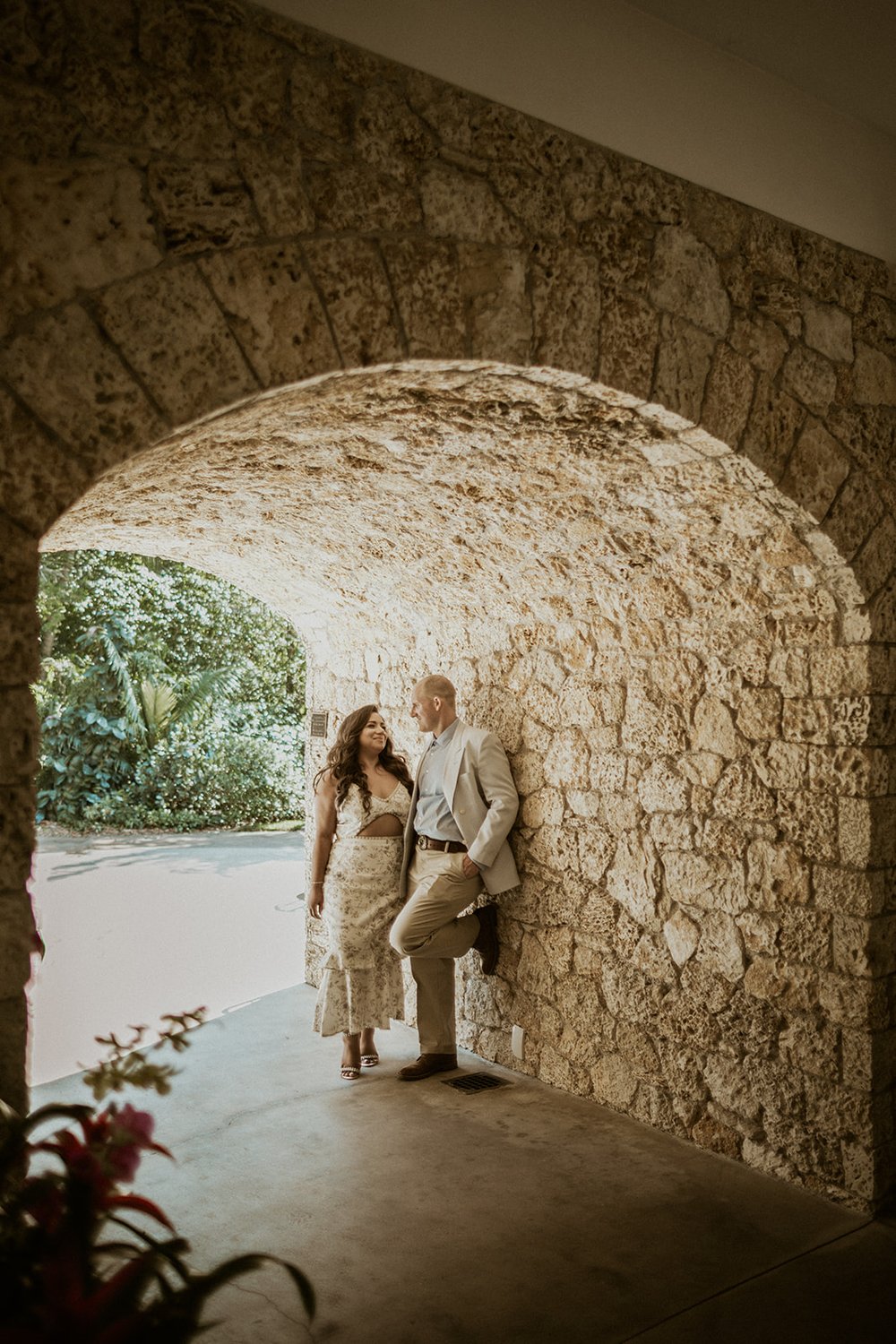 He stands against the stone underpass with his future bride on his side. 