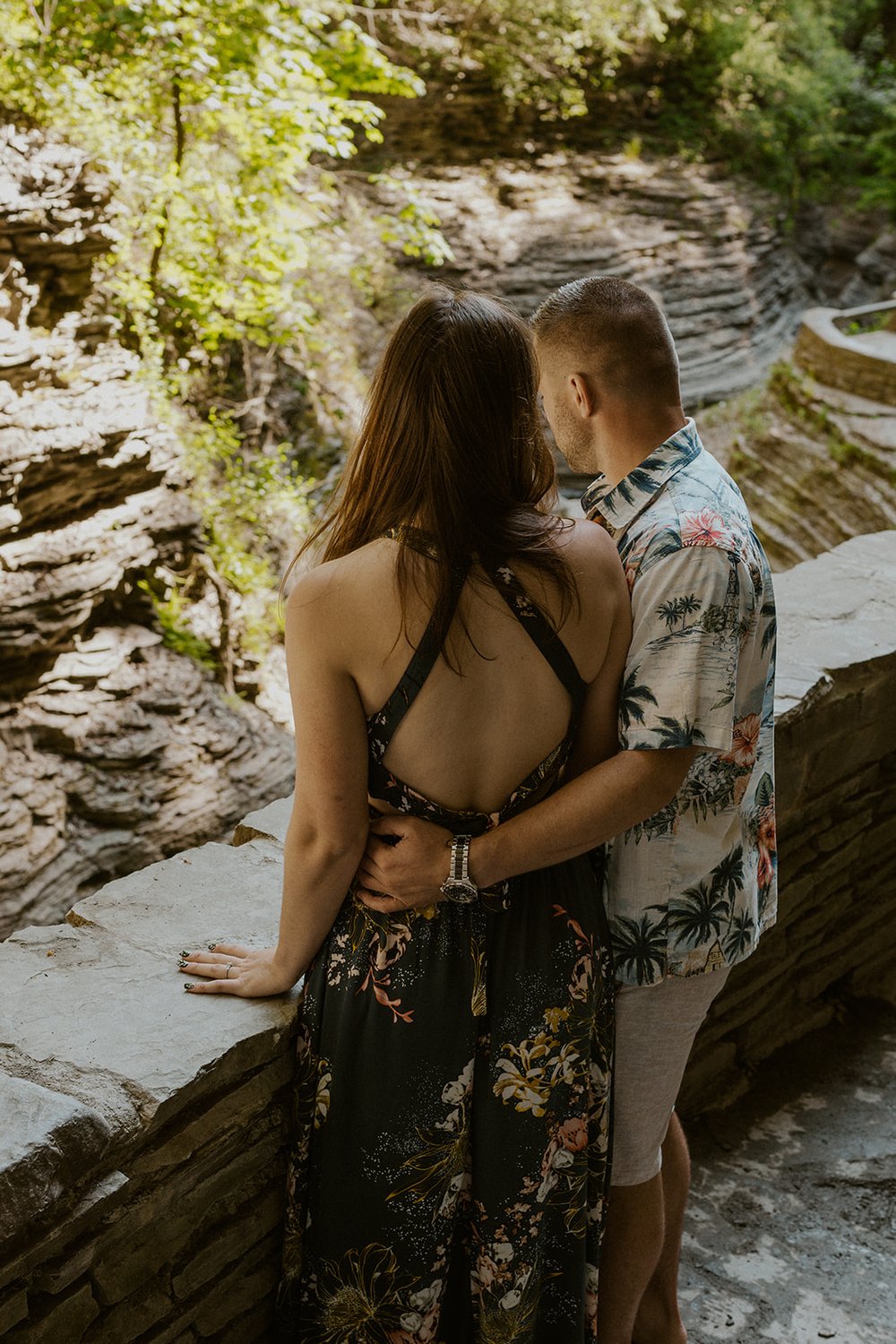 Hade holds his bride as they both look down over the ledge admiring the beauty of Watkins Glen State Park.
