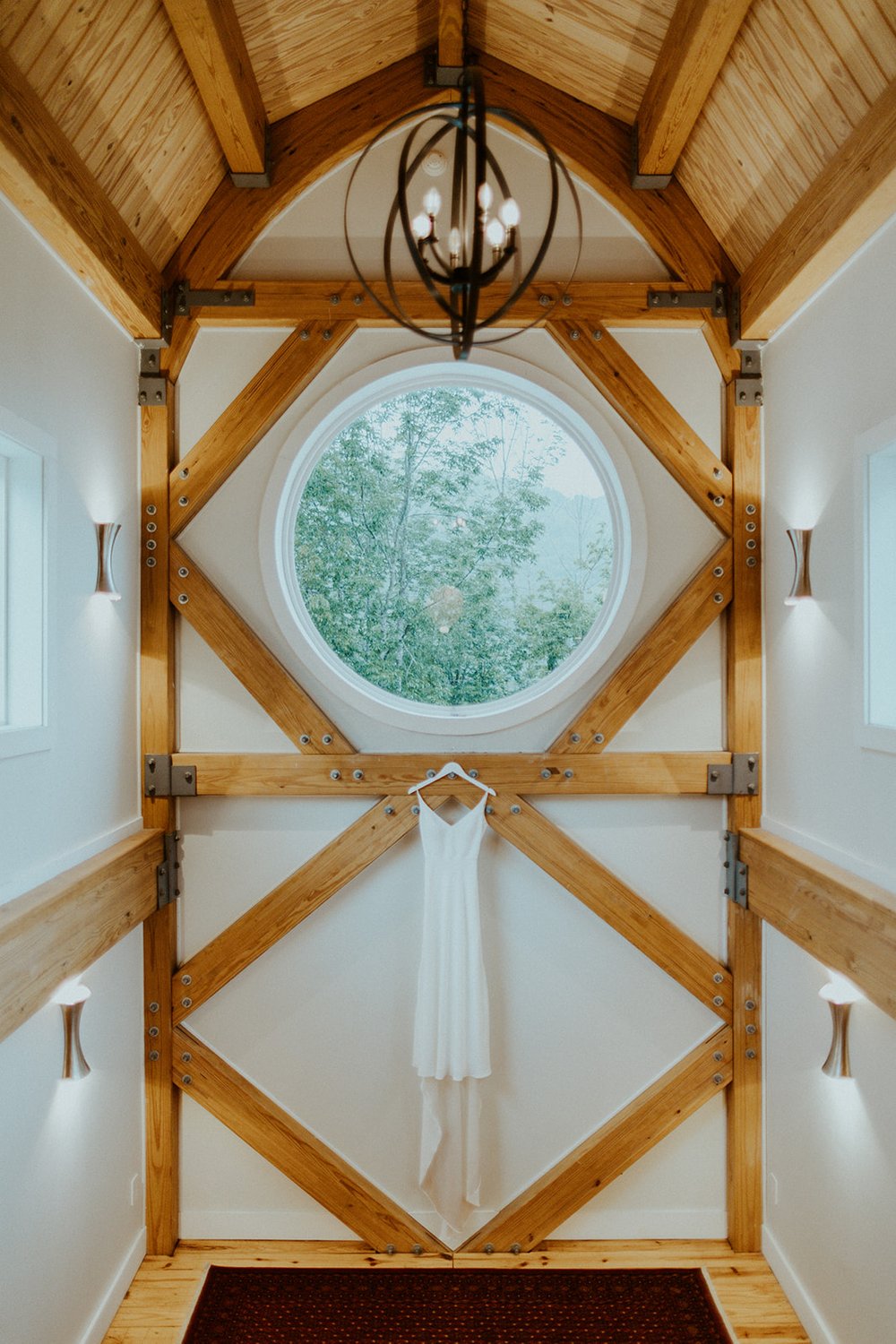 The brides gown hangs just below a window view of the catskill mountains.