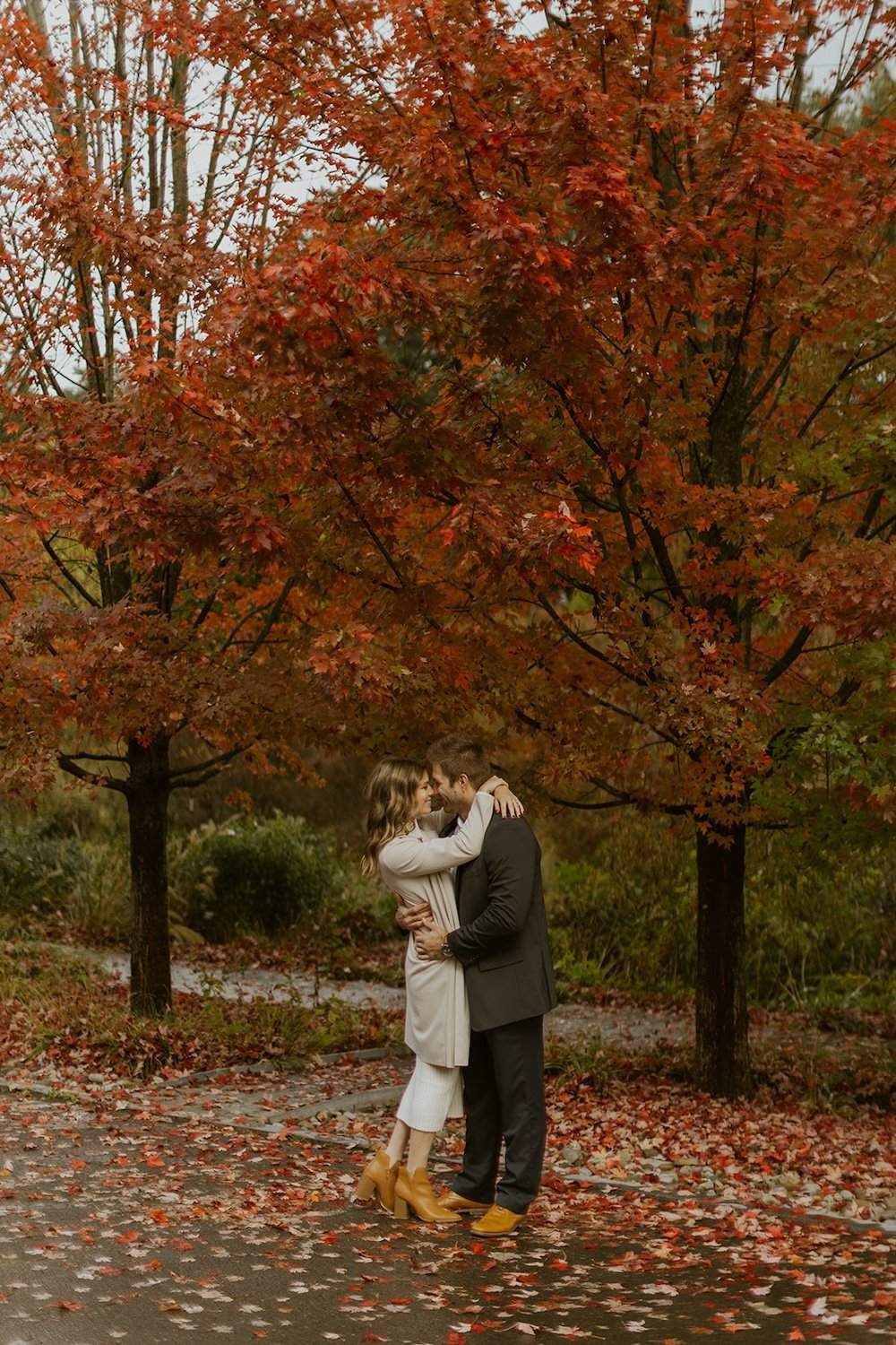  The couple share a moment under the fall foliage sharing a moment forehead to forehead.  