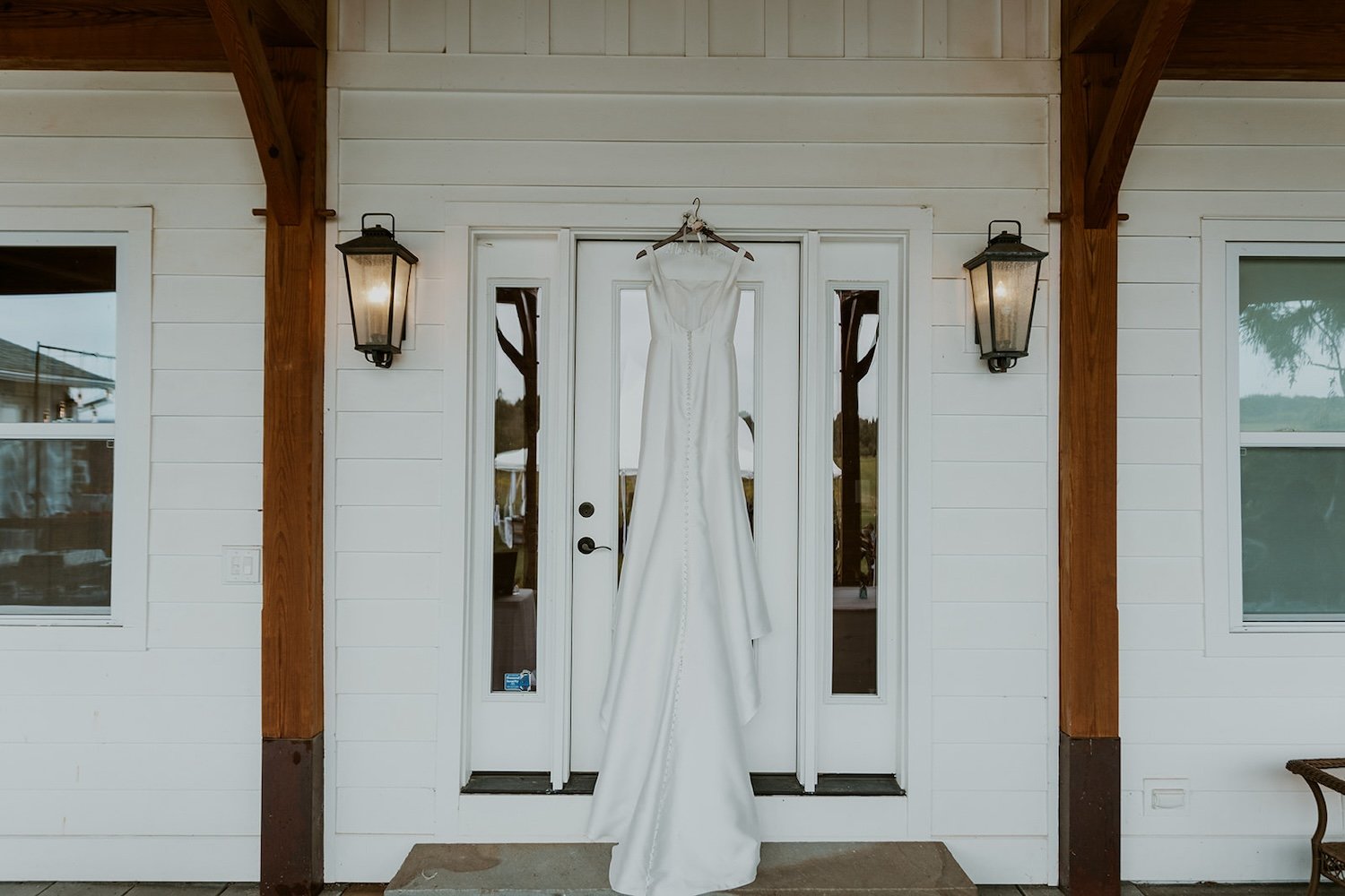 The brides beautiful wedding gown hanging on the front door of the Ithaca home.