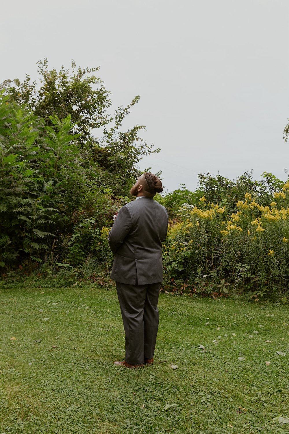 The groom standing in the yard waiting for his bride to greet him.