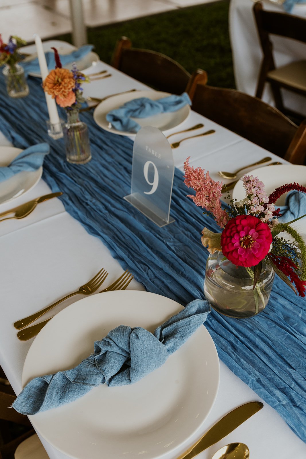 The table setting's decorated with touches of gold, light blue and bright fuchsia and pink florals.
