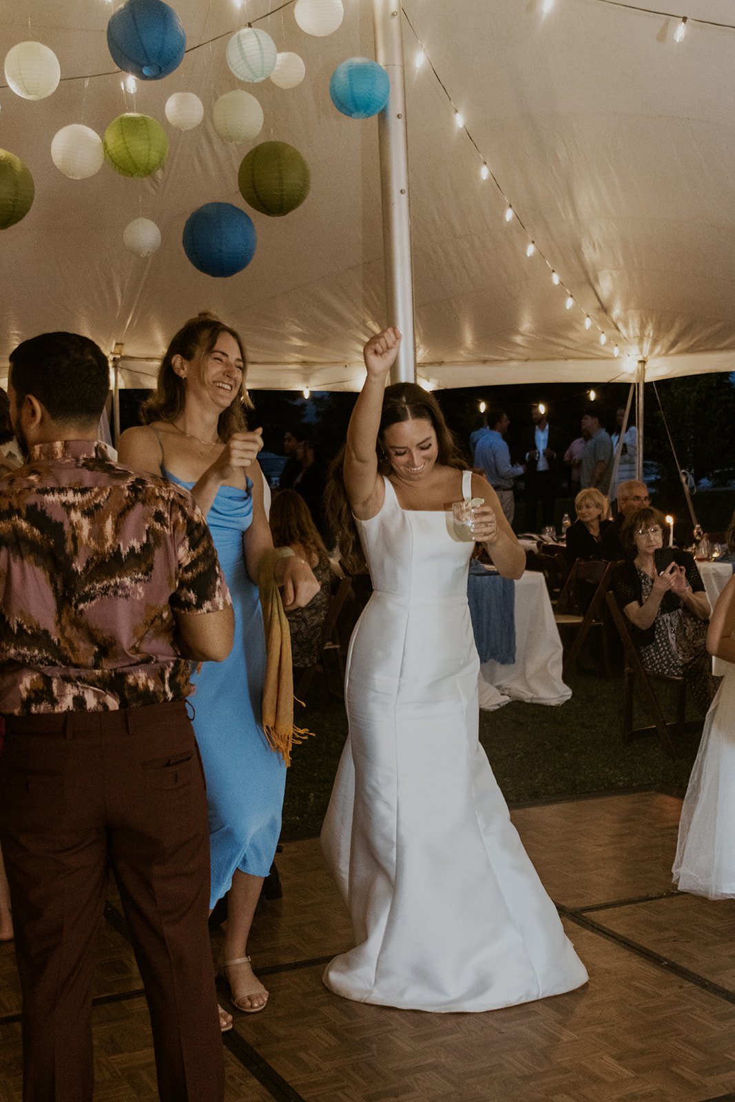 The bride dances happily with a few of her wedding guests.