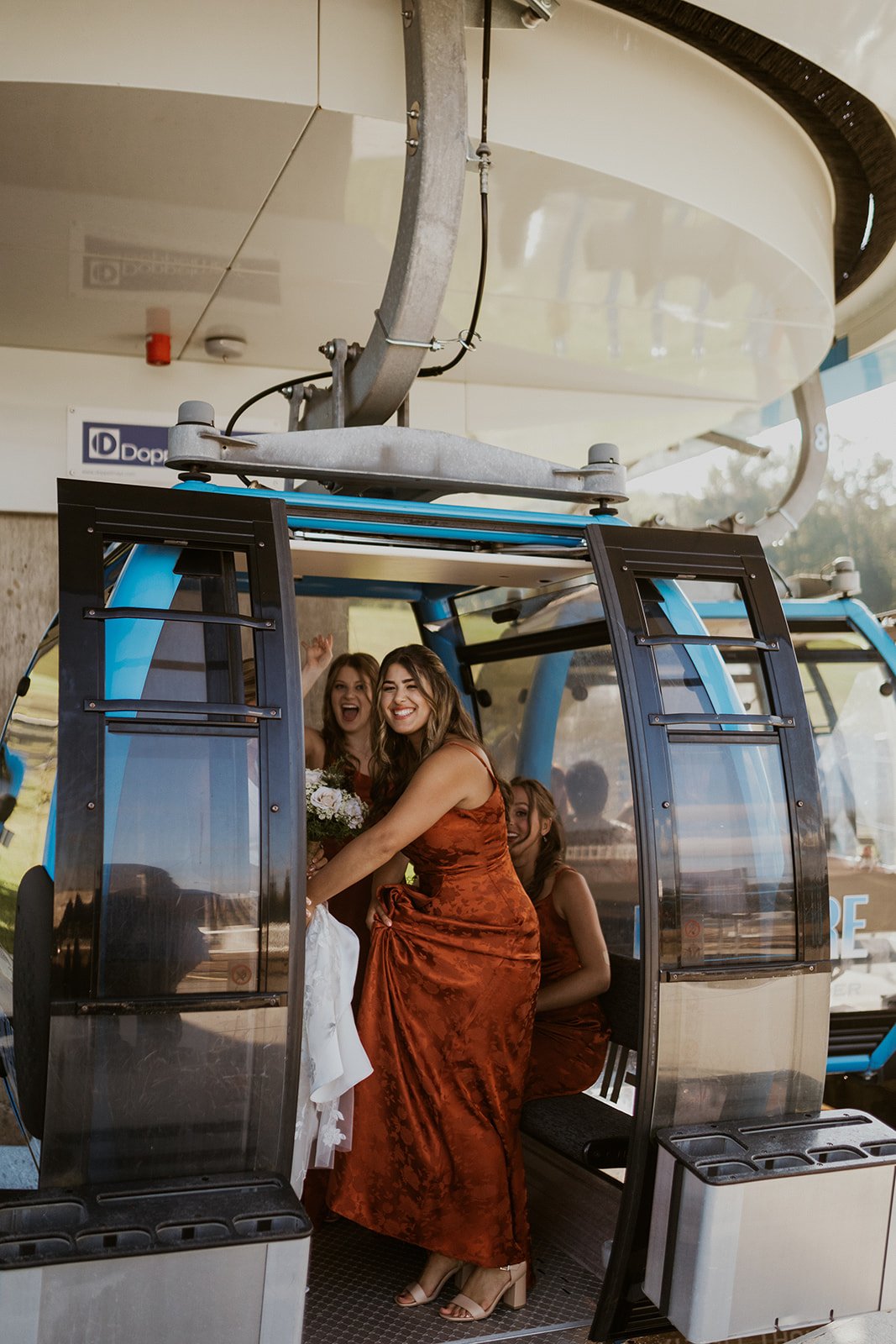 The bridal party smile with excitement for their ride on the gondola. 