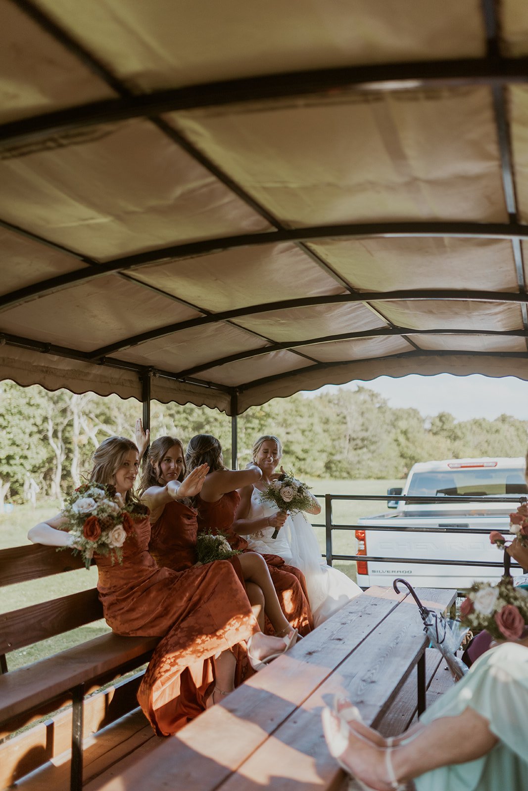 The bridal party sit on their hay ride as they enter the ceremony location. 