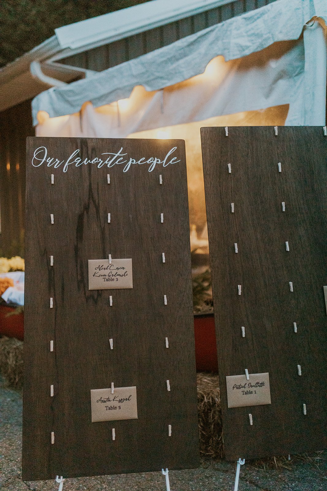 Table placement boards decorated with white chalk print and tan envelopes. 