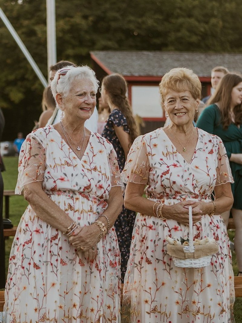 The grandmothers of the bride and groom dressed in their floral white dresses. 