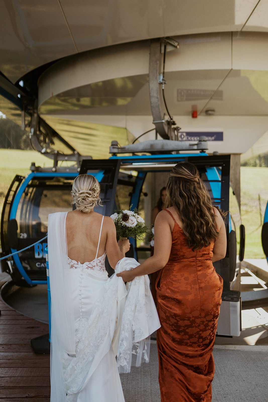 The bride and her bridesmaid prepare to get into the gondola. 