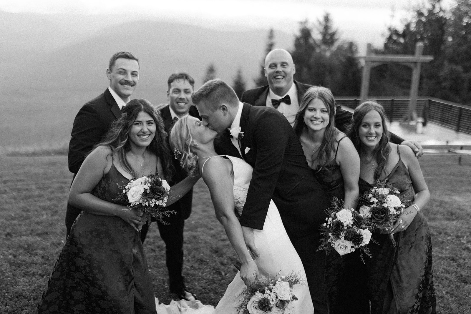 Black and white photo of the groom dipping his bride for a kiss. 
