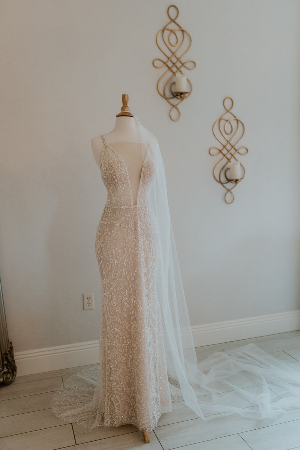 The dress on a mannequin with the veil wrapped around it. 