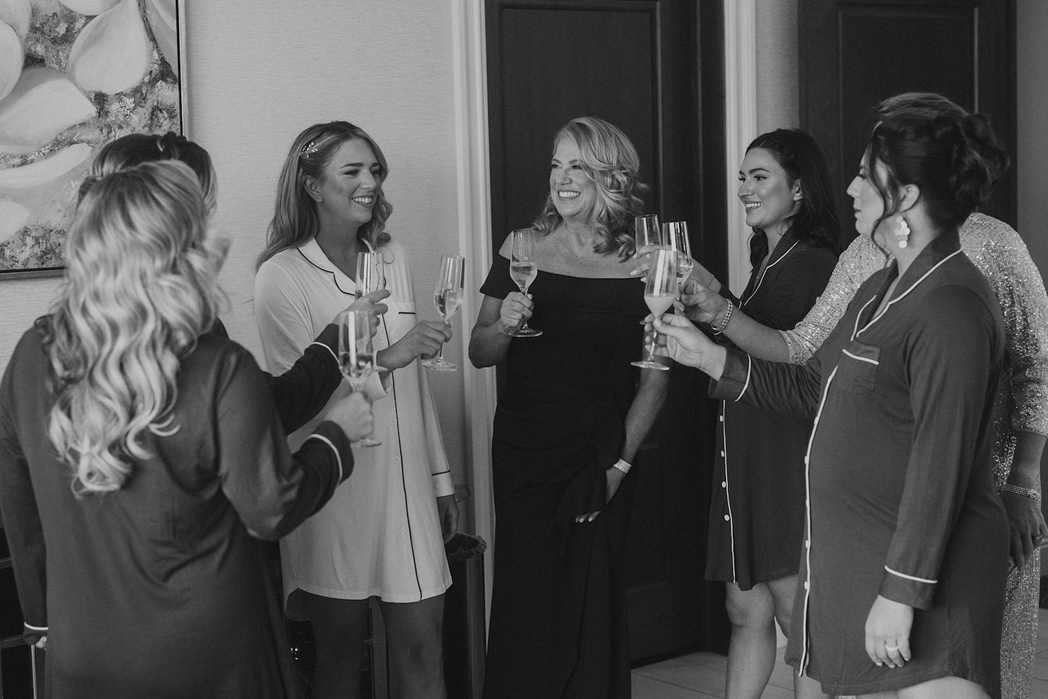 The bridal party gathers around the bride for a toast in celebration.