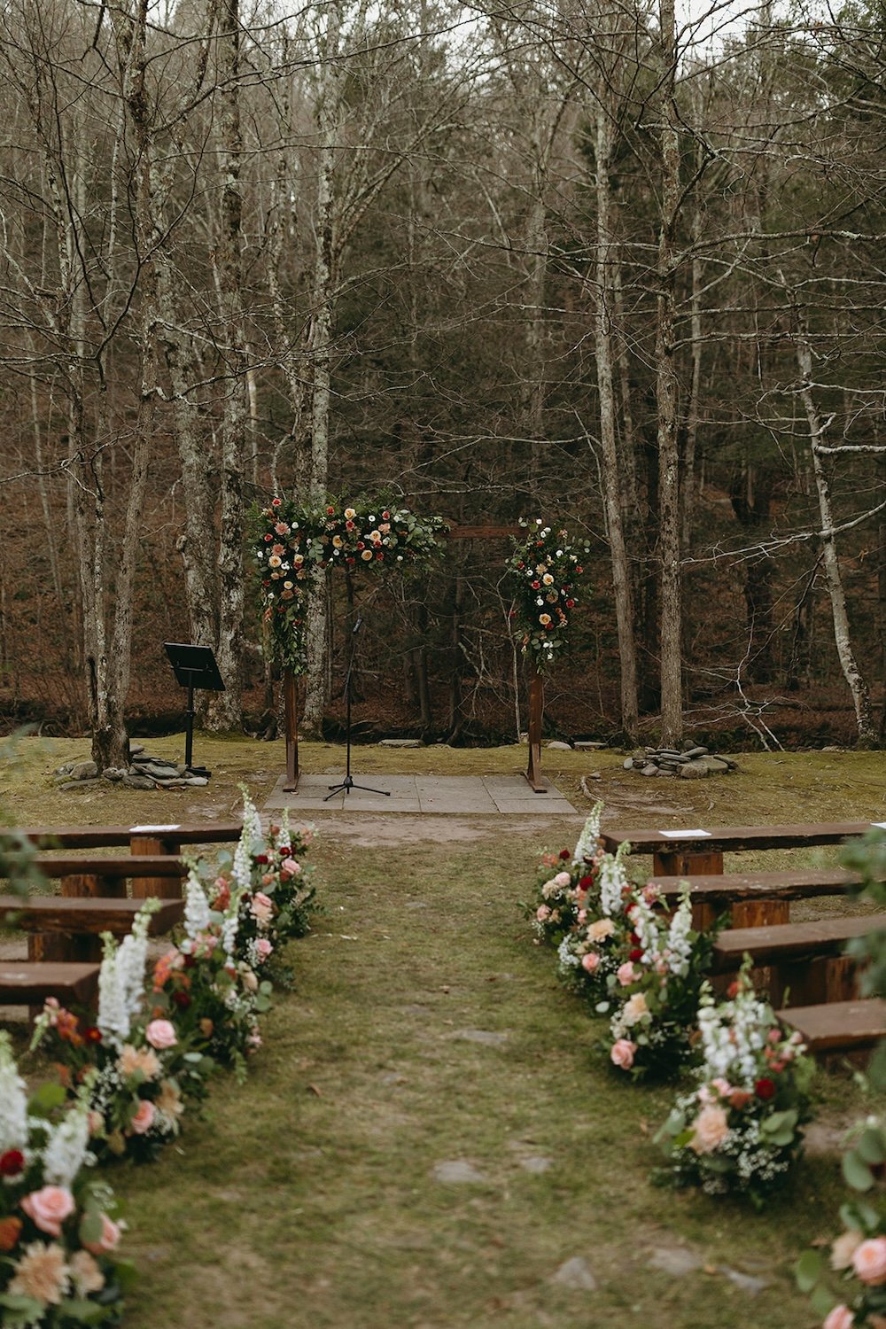 The outdoor ceremony decorated and beautiful red, pink and white florals.