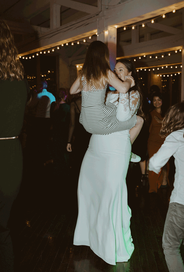 The bride dances with one of the children at the wedding. 