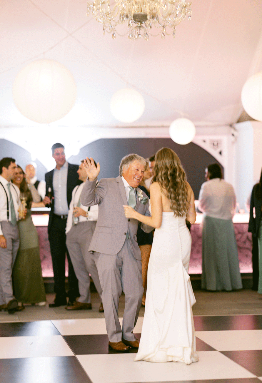 The bride and her father dance together. 