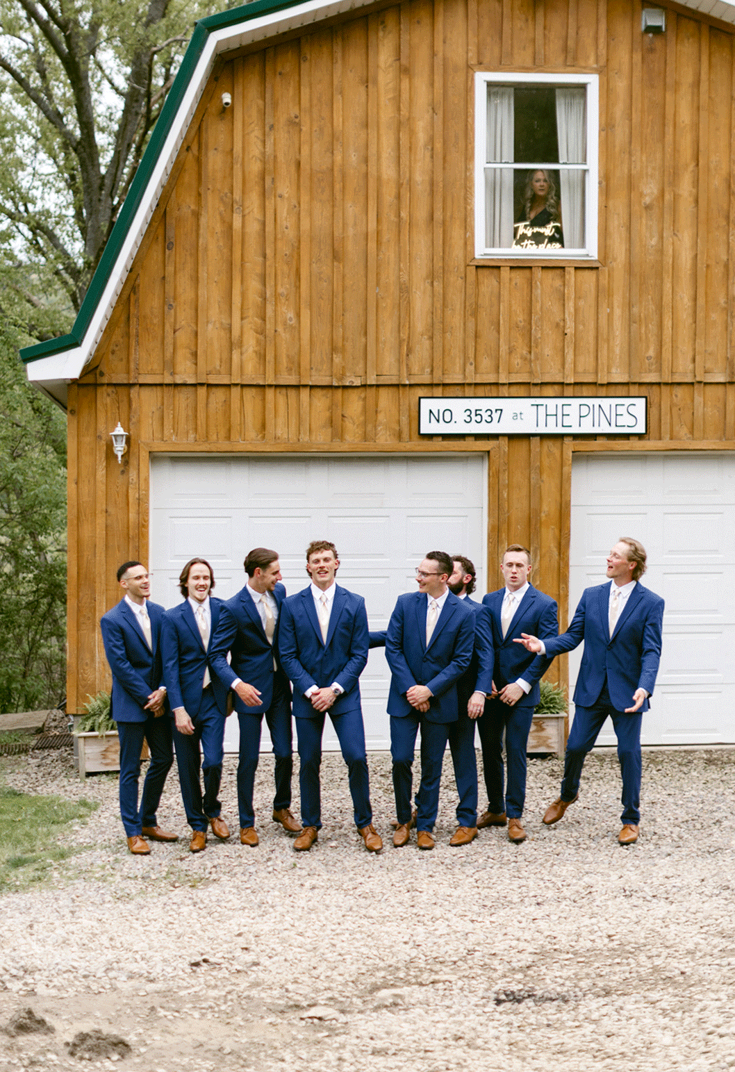 Grooomsmen walk together as a group laughing with one another.