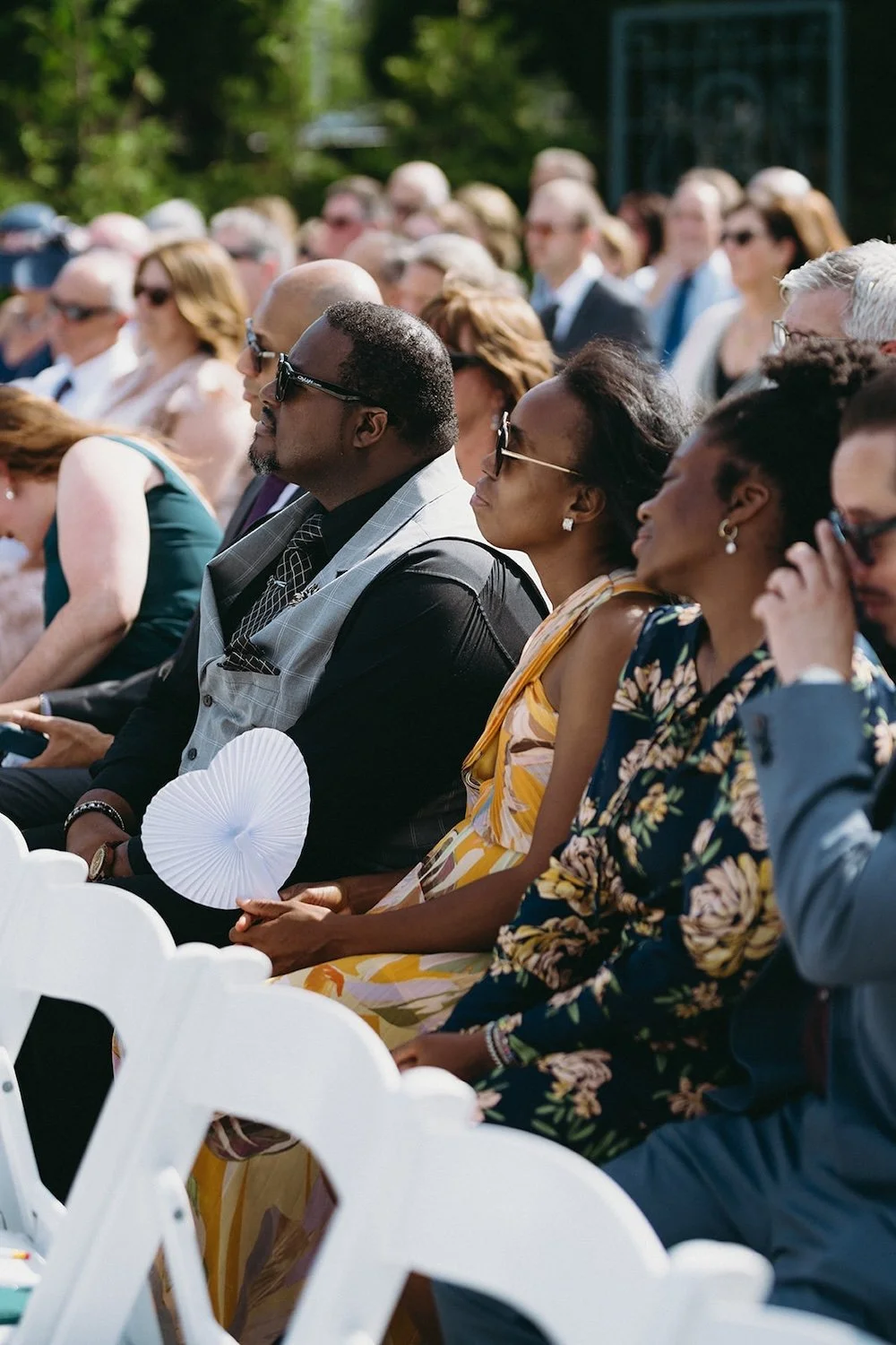 Guests of the wedding sitting in the ceremony seating awaiting the bride.