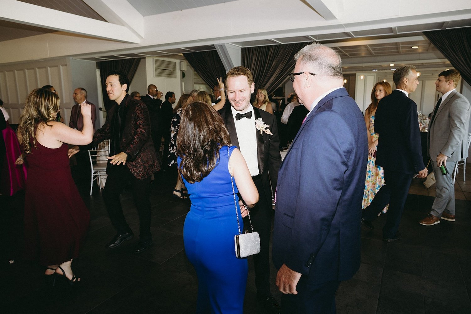 The groom talks with family and friends of the wedding couple. 