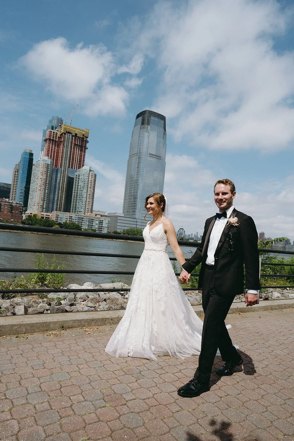 The couple walk the path with the city as their background.