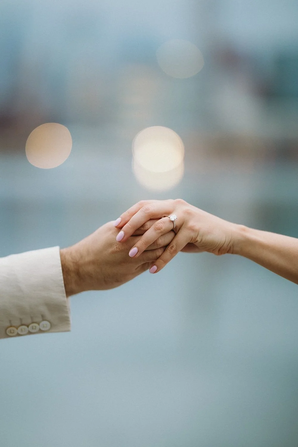 the couple holding hands showing of the engagement ring. 