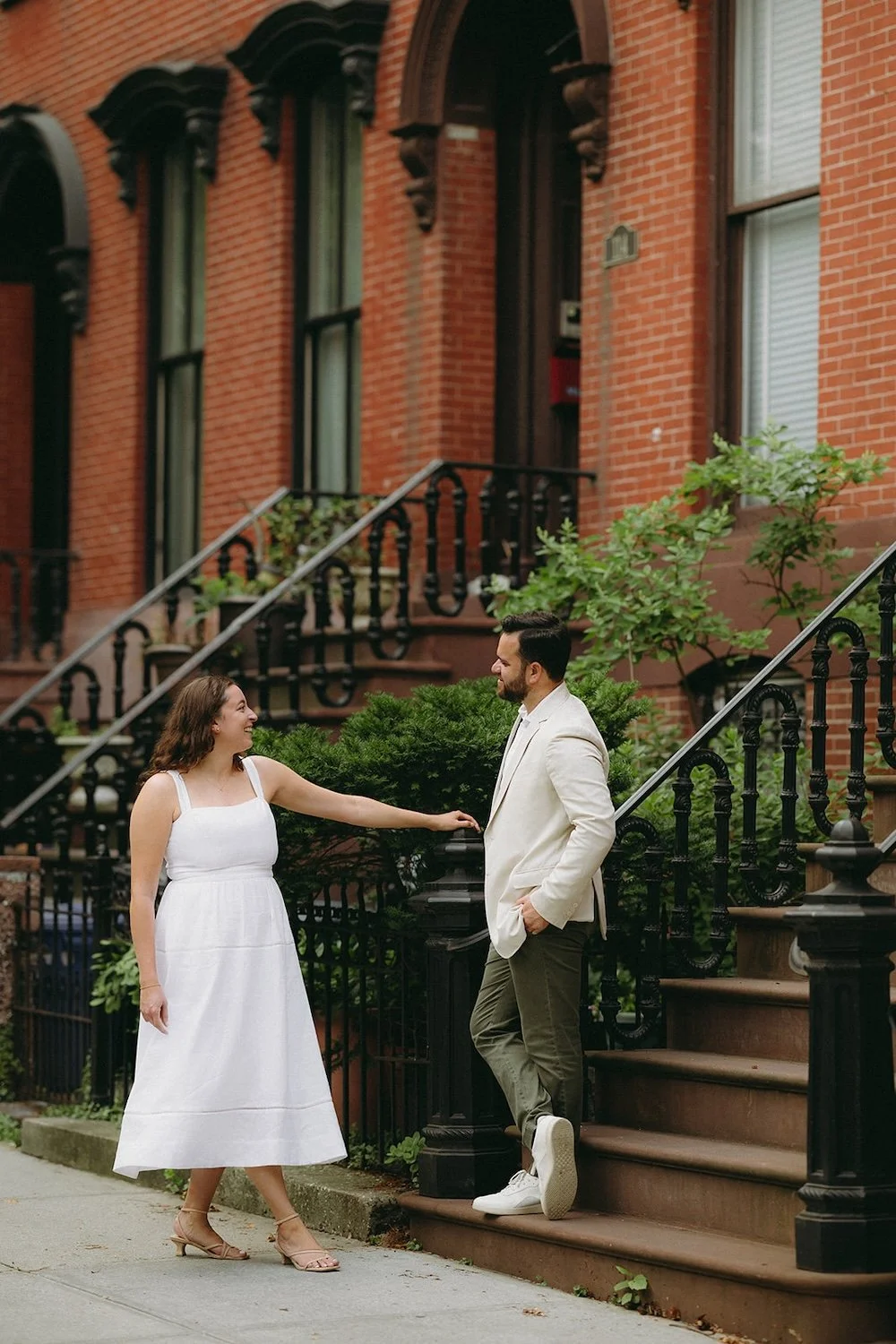 The future bride admires her groom standing on the stairs. 