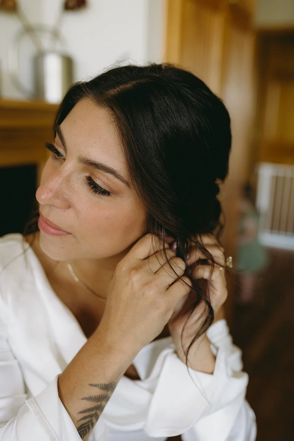 Close up photo of the bride putting her earrings on. 