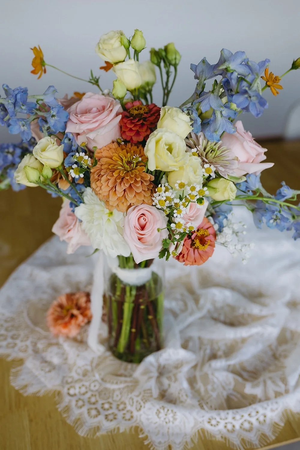 Wedding bouqout decorated with assorted color florals including yellows, oranges, reds and pinks. 