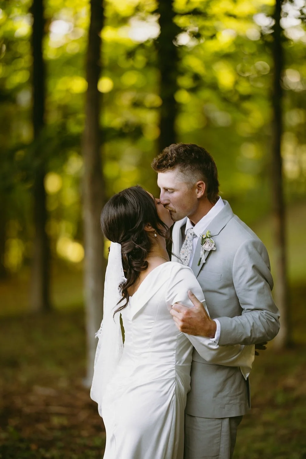 The groom holds his bride as they share a kiss. 