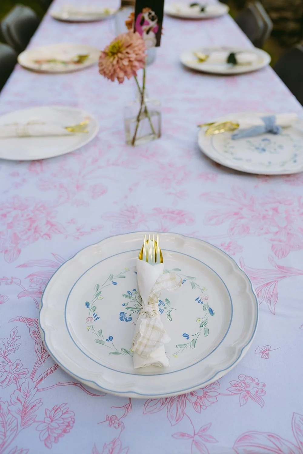 Detail photo of the thrifted plates on the floral pink tablecloth. 