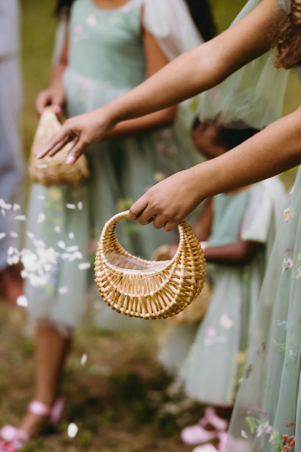 Detail photo of the flower girls dropping flower petals. 