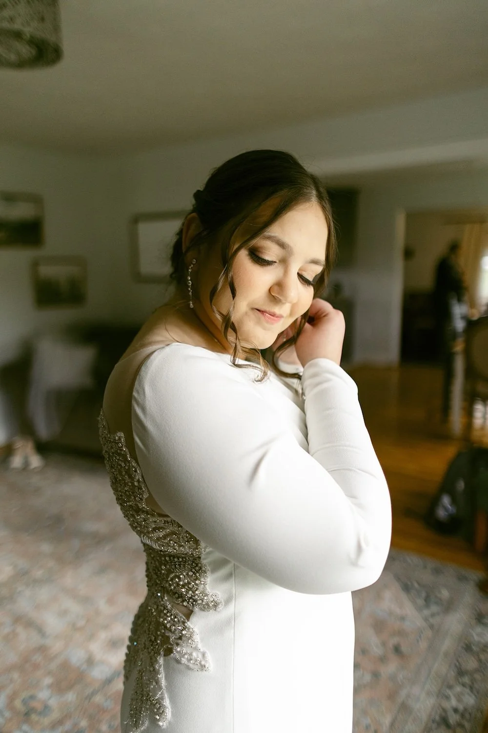 The bride puts her wedding jewelry on. 
