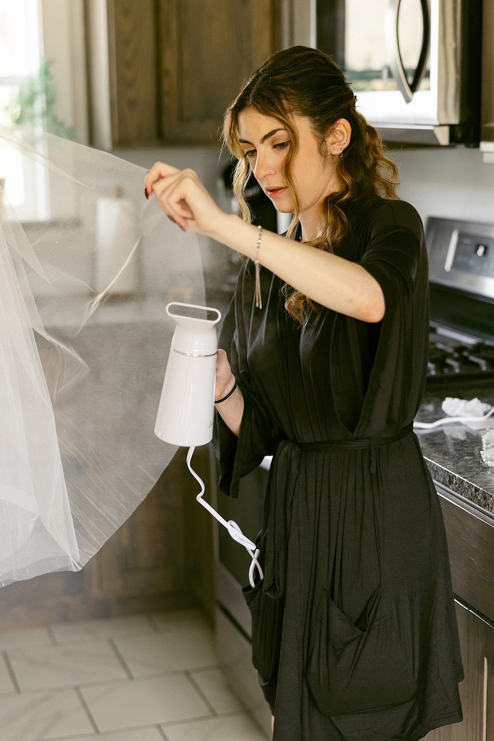 Bridesmaid steams the brides veil. 