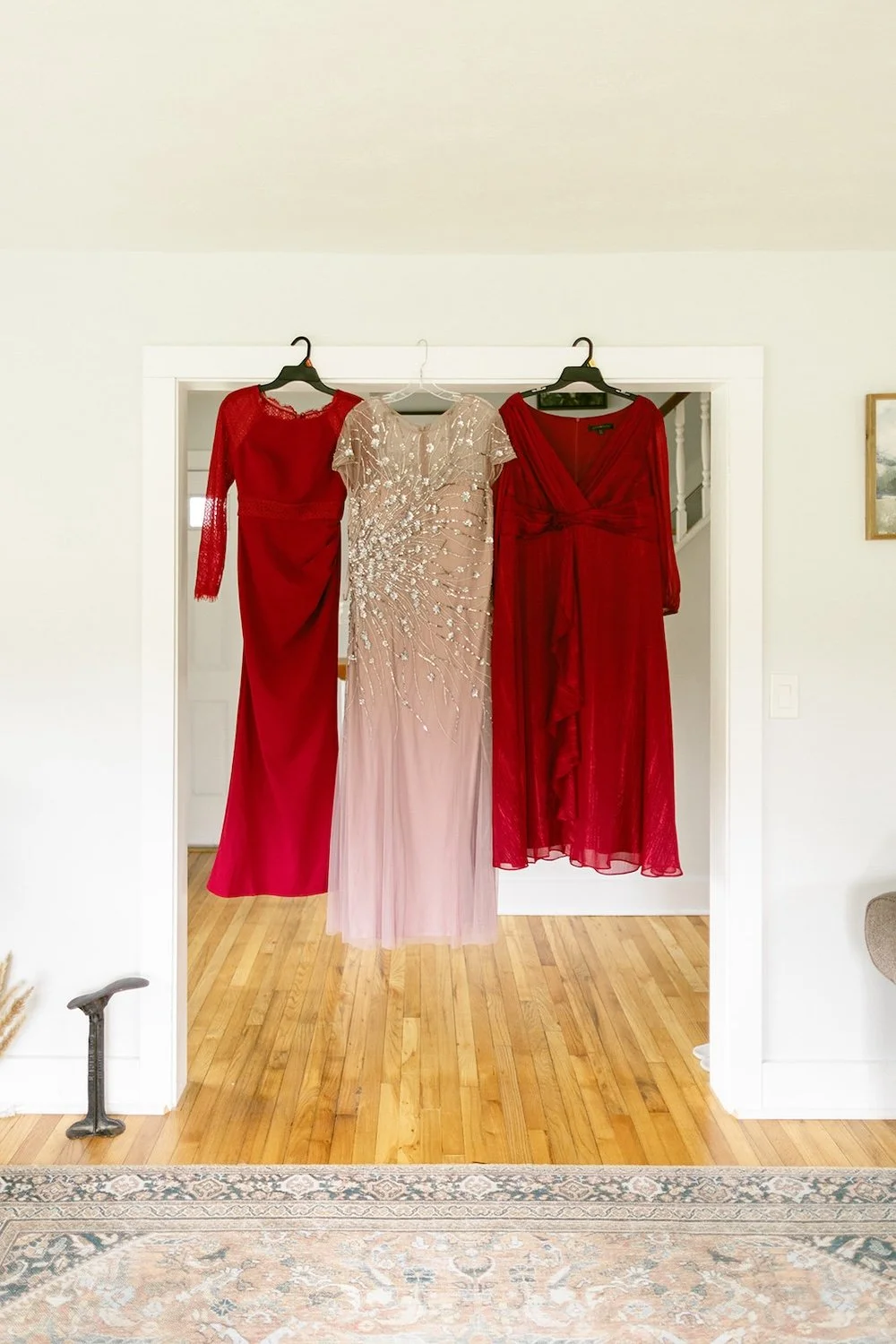 Bridal party dresses hang in the doorway. 