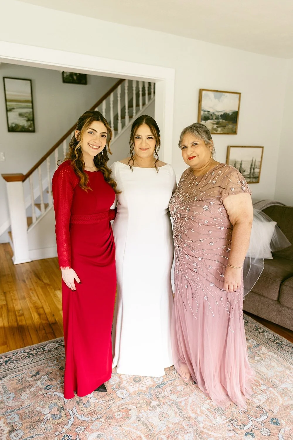 The bride stands with her mother and maid of honor decorated in their wedding attire. 