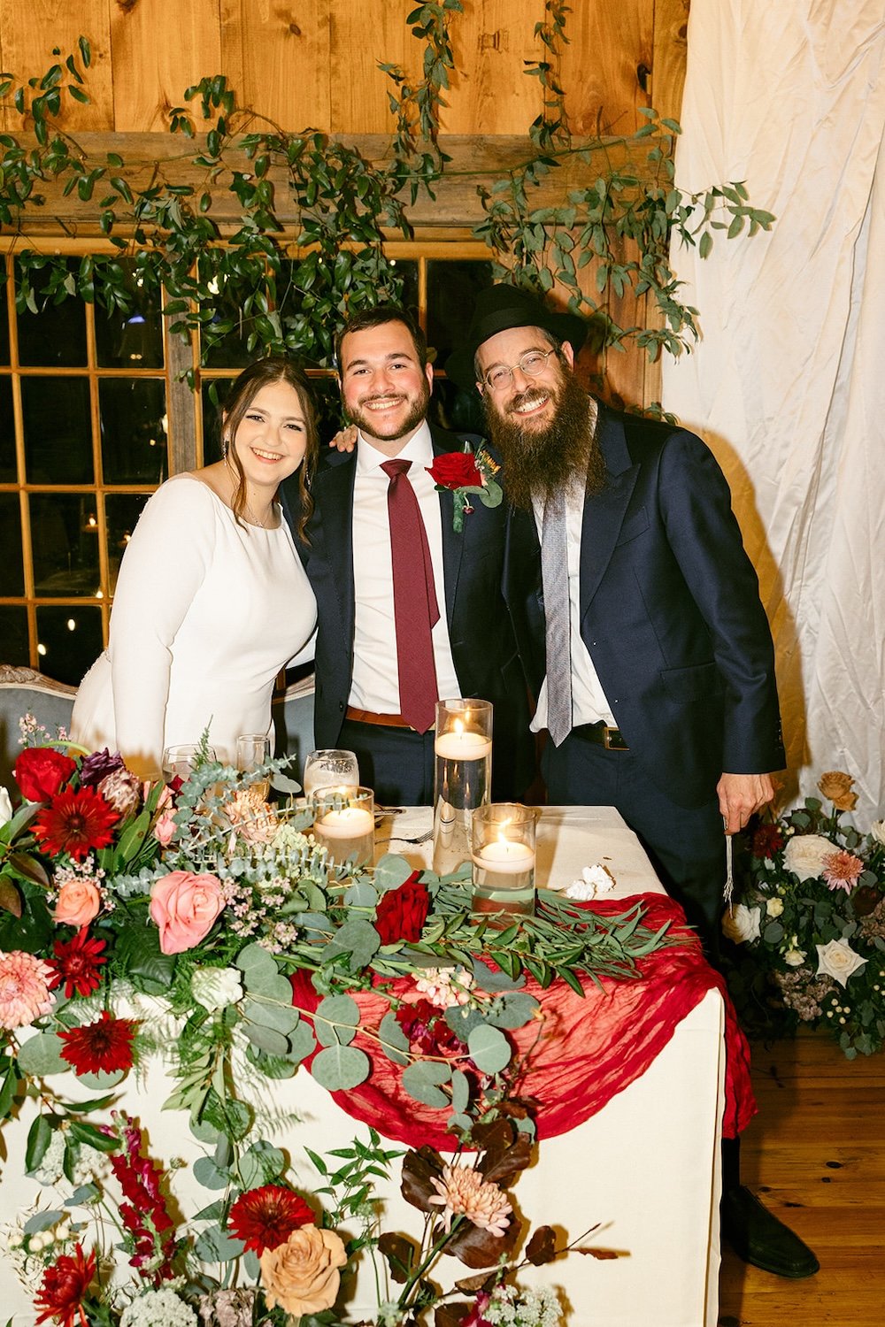 The couple stand posing with their college rabbi. 