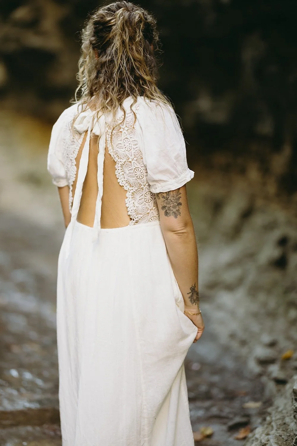 Detail photo of the future brides dress decorated with delicate lace, open back held together with a bow. 