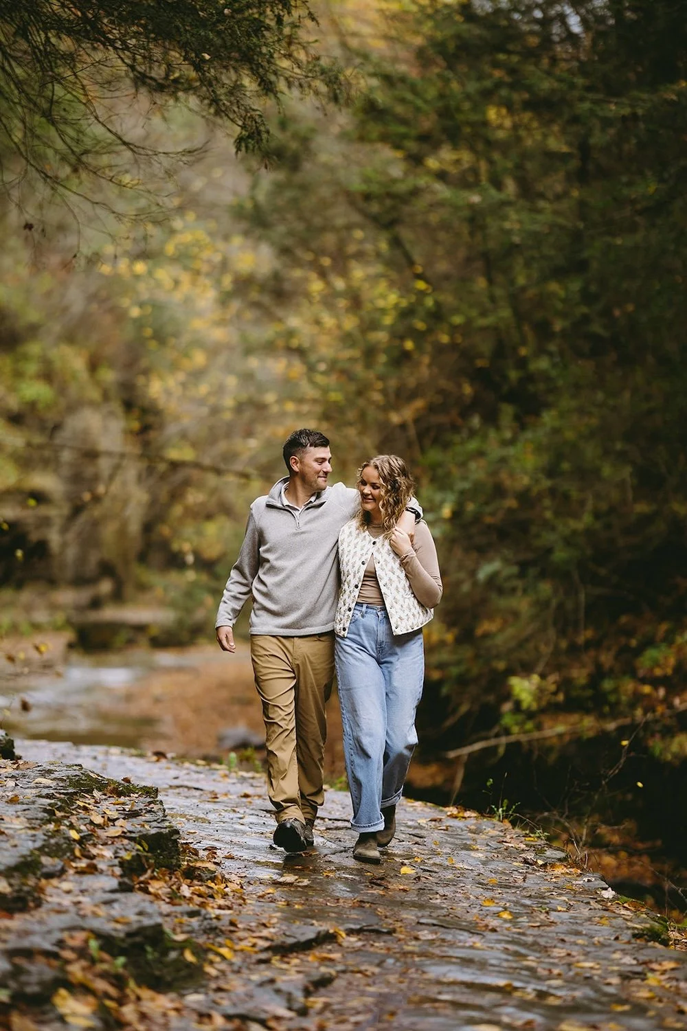 The future groom wraps his arm around his bride to be walking the gorge on a beautiful fall day. 