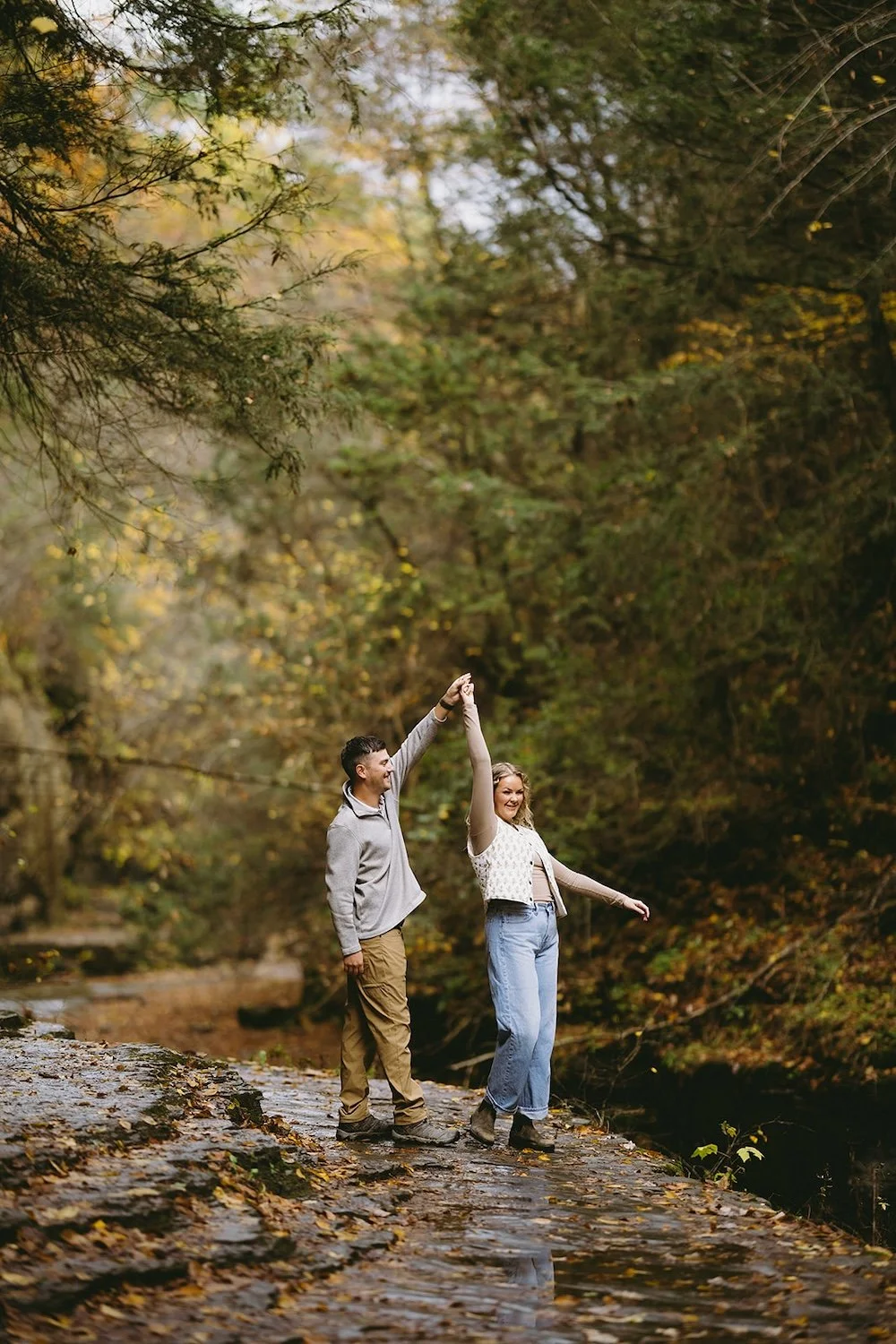 The future groom spins his bride to be in circles as they share a dance together. 