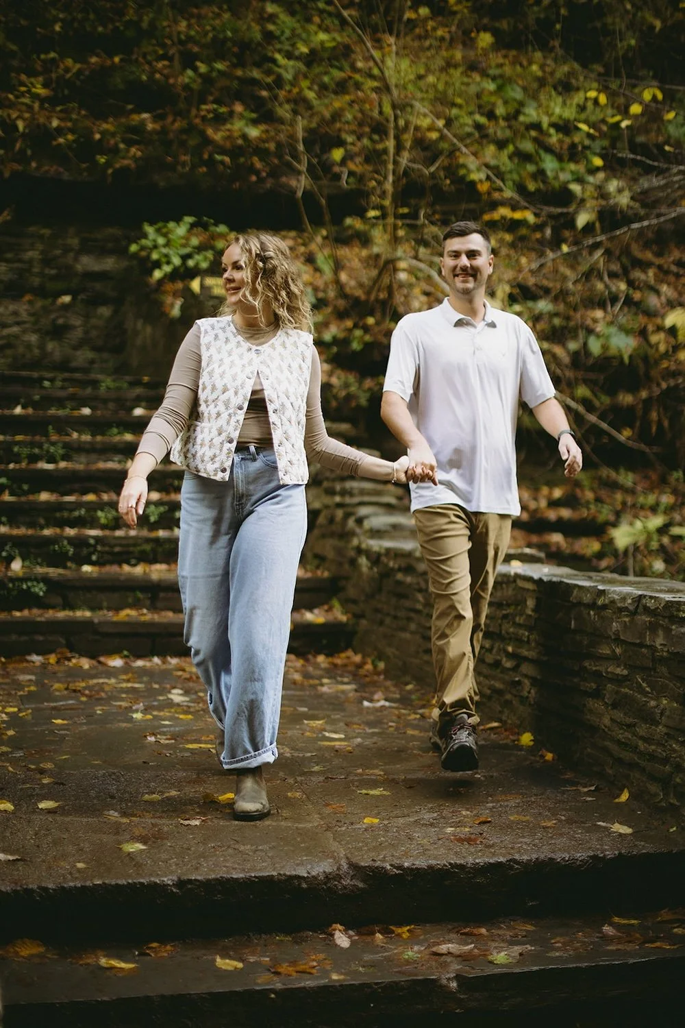 The happy couple walk hand in hand down the steps of the bridge. 