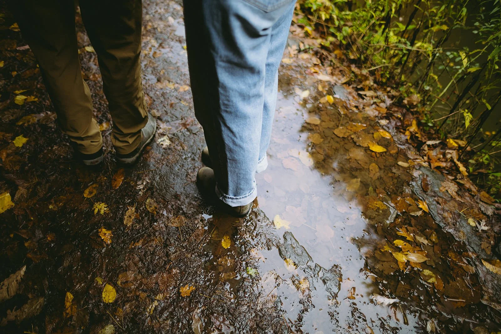 Detail photo of the couple walking through the puddles that line the gorge. 