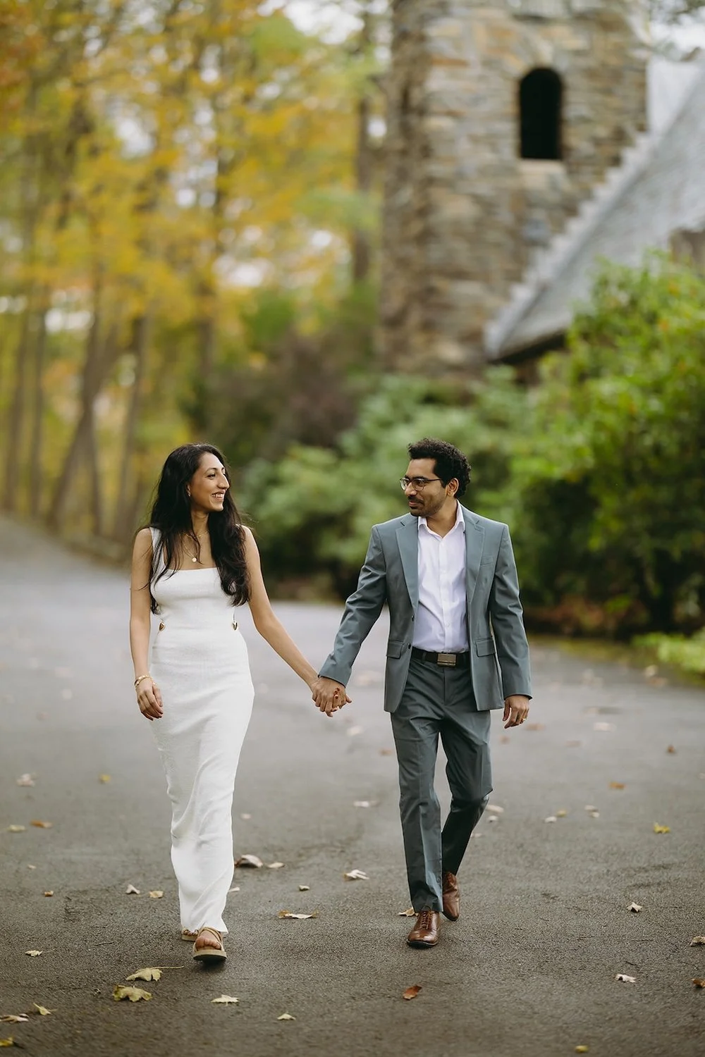 The couple hold hands while walking the path to the church.