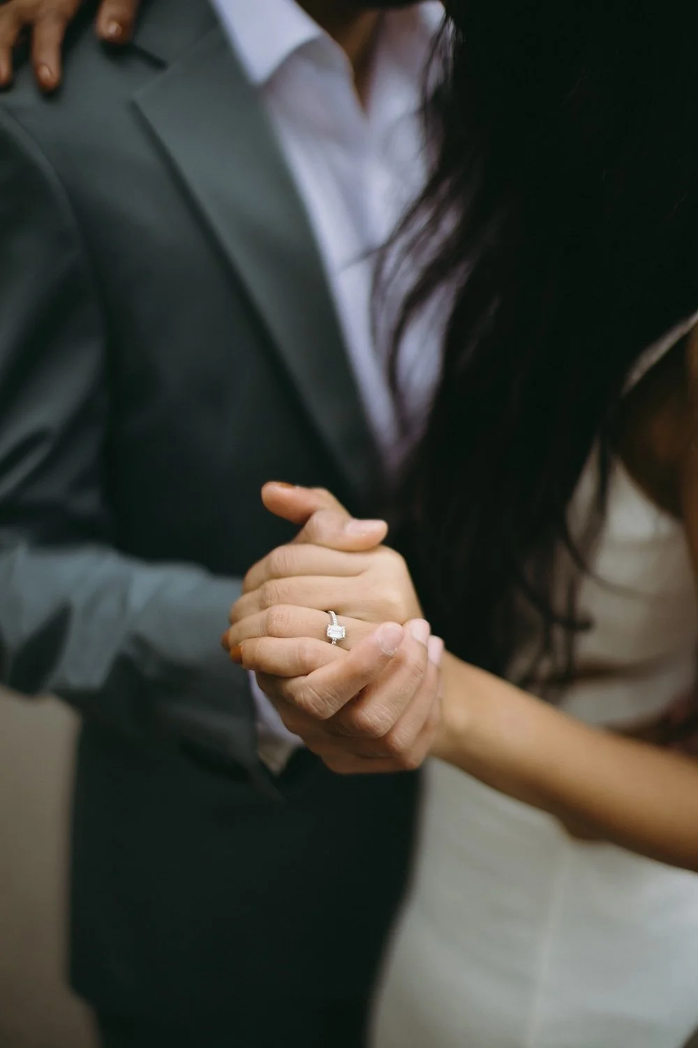 Detail photo of the future groom holding his brides hand.