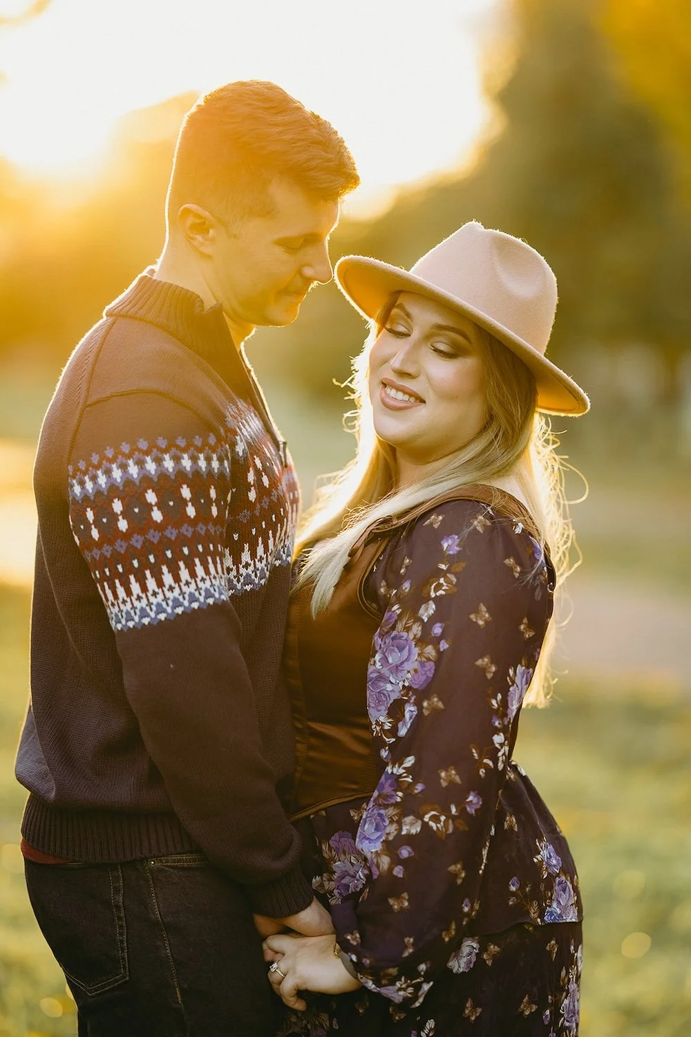 The future groom admires his future bride as she looks toward the camera with a smile. 