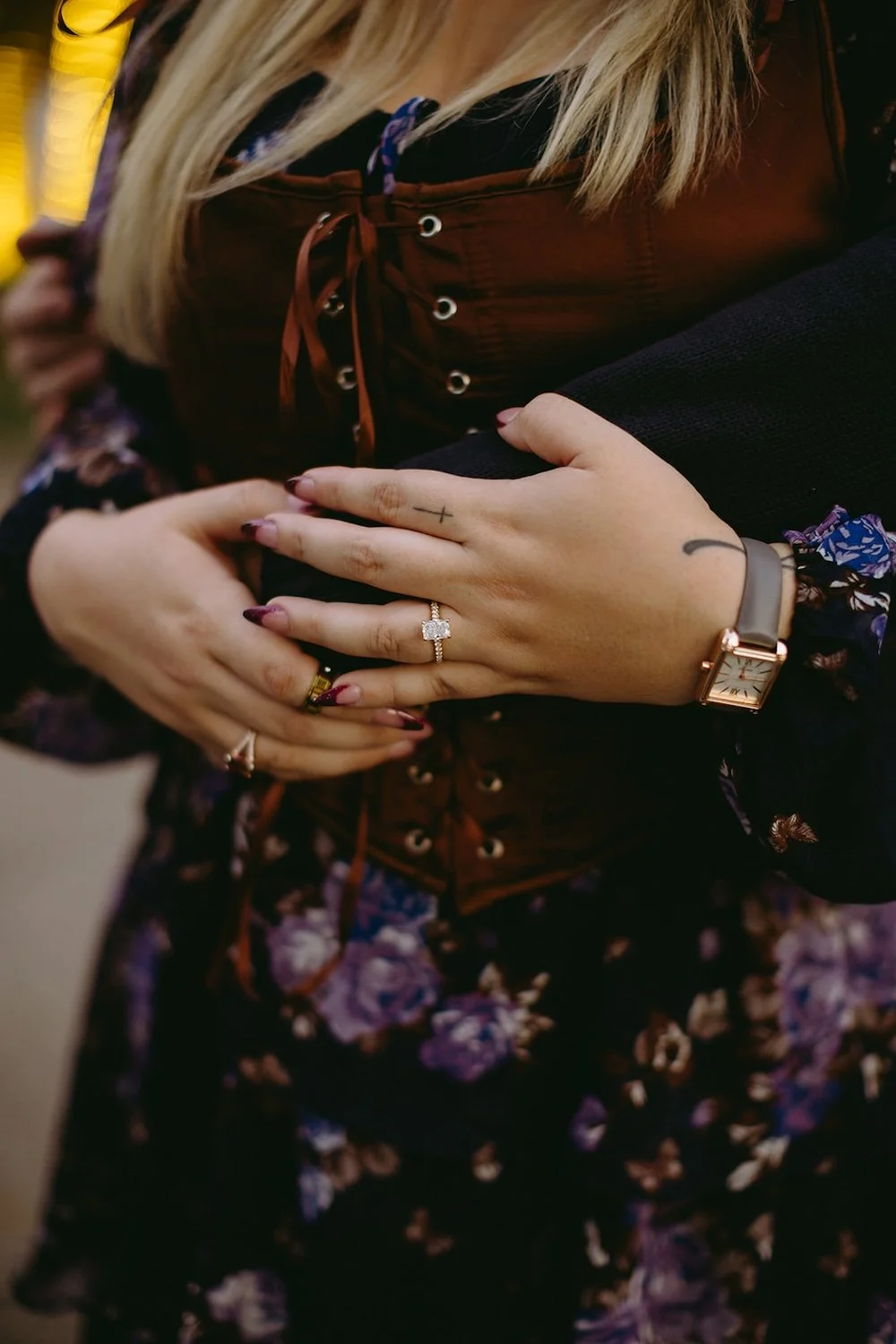 Detail photo of the couples hands resting on the future brides belly. 