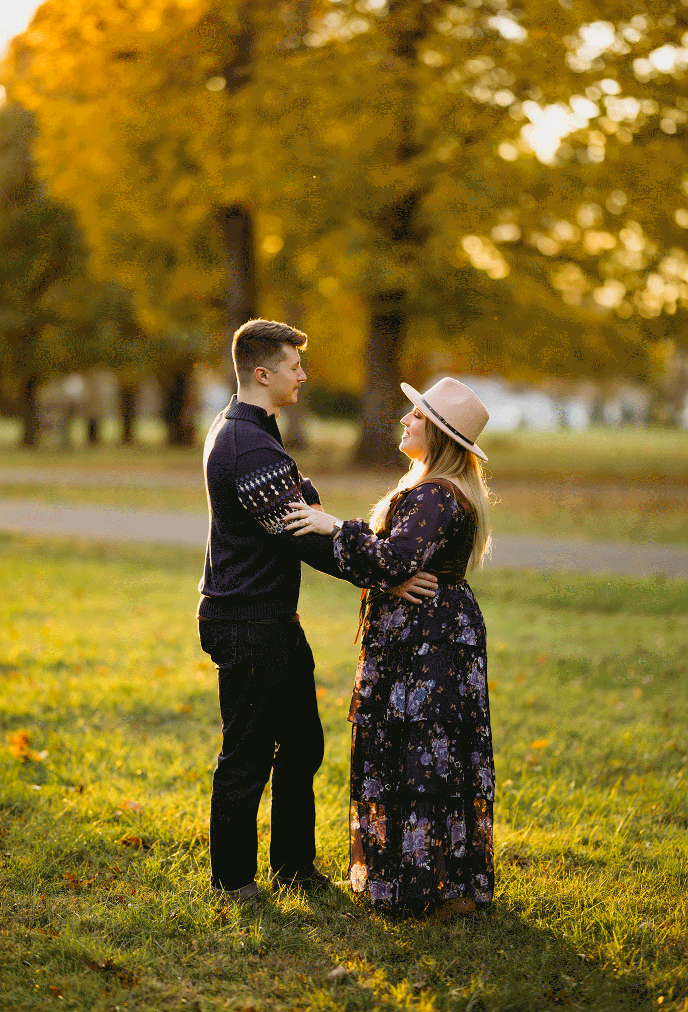 The future groom spins his bride in circles while in the park. 